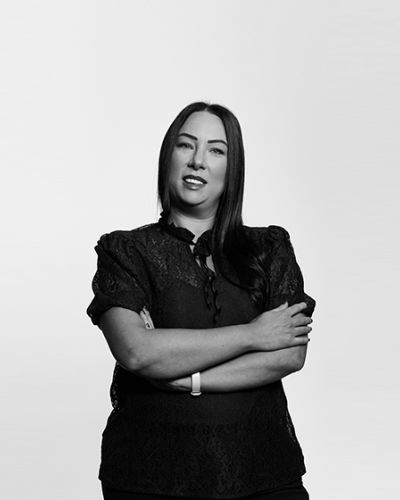 A black and white image of Wills, Trusts & Probate solicitor, Danielle Blaylock, standing in front of a gradient grey background