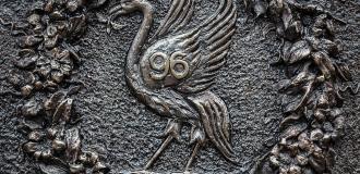 A brass plate showing the Liver bird surrounded by a wreath in commemoration of Hillsborough. 
