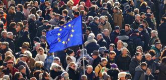 An EU flag flown in a group of people.