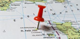 A red pushpin is stuck in a map of the English Channel, showing the English southern coastline at the top of the picture and the French north-coast at the bottom of the picture.