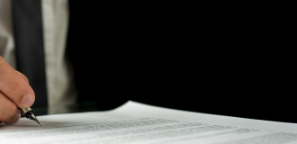 male hand signing a document with a fountain pen