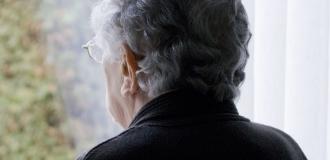 elderly woman looking out of window