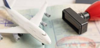 Open passport with toy plane and stamp lay on top.