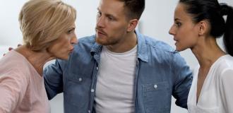 An old and young women arguing with man stood in the middle