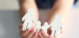 child holding a cut-out family in hand