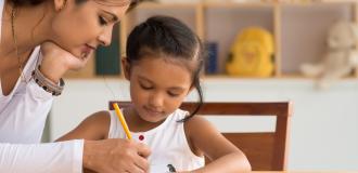 A woman helps her child with her homework.