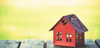 A small red house on a sunny background.