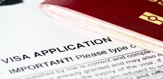 A photo of a British visa application and a maroon passport.