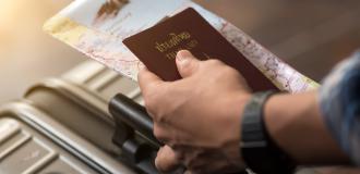 A hand holding a passport and a map