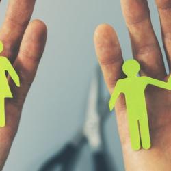 Two hands holding divided paper chain people