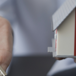 Keys and a small house in a woman's hands