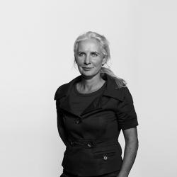 A greyscale photo of Rachel Chapman, Prison Law Consultant. She is wearing a black collared top, and is smiling slightly